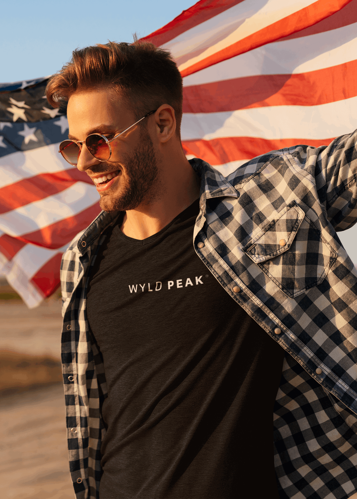 Wide lifestyle shot of Wyld Peak Signature tee in black with American flag design.