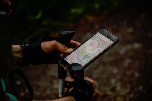Hands holding a smartphone with GPS navigation open during a mountain hike