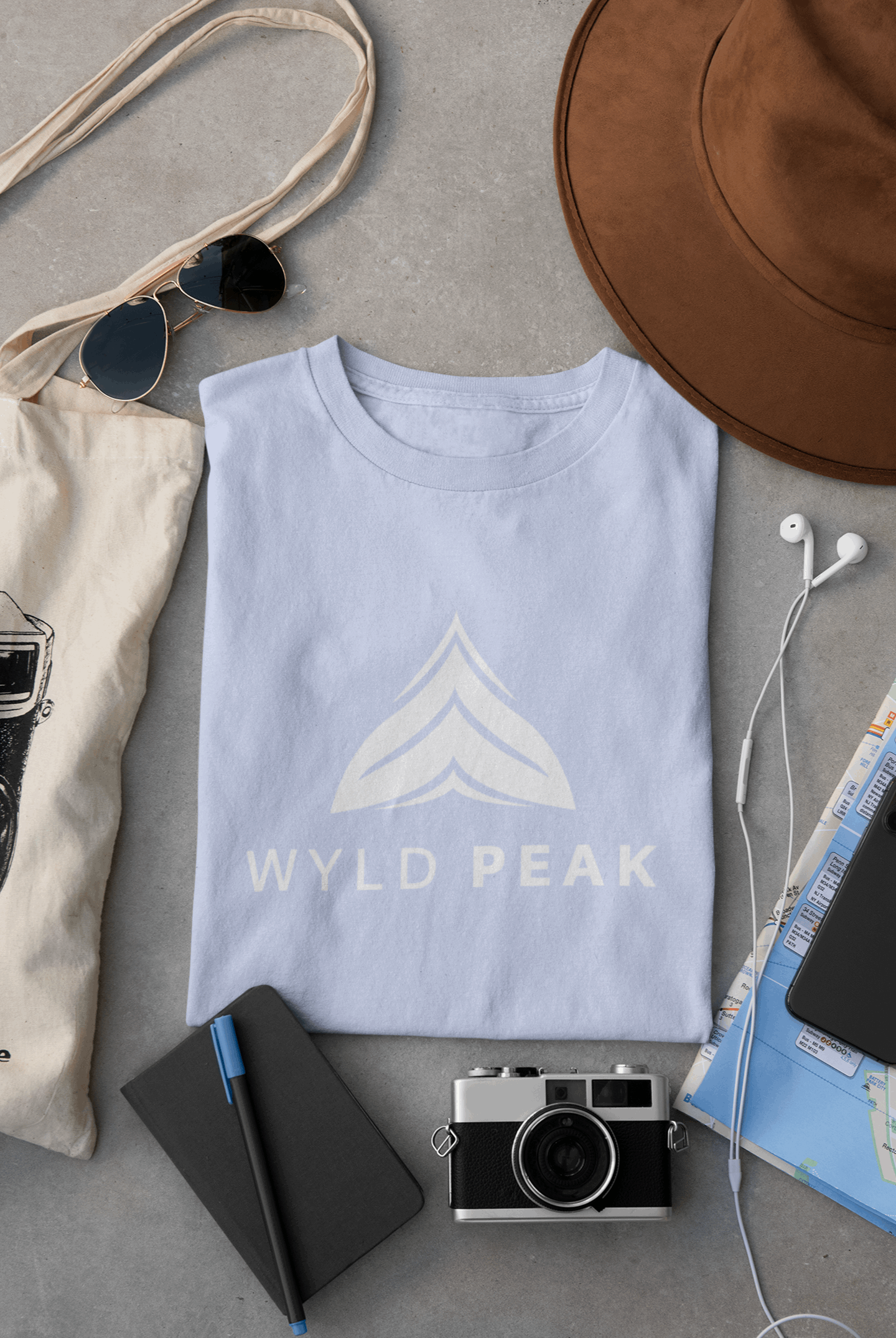 Wyld Peak Active men’s organic cotton t-shirt in light blue laid flat on a desk