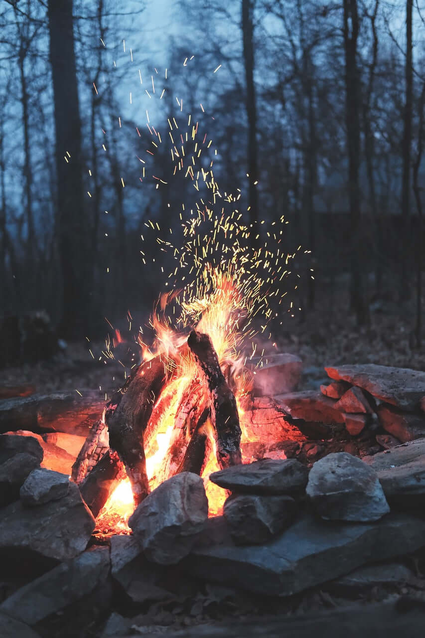 Fire burning at a campsite during an outdoor hiking adventure.