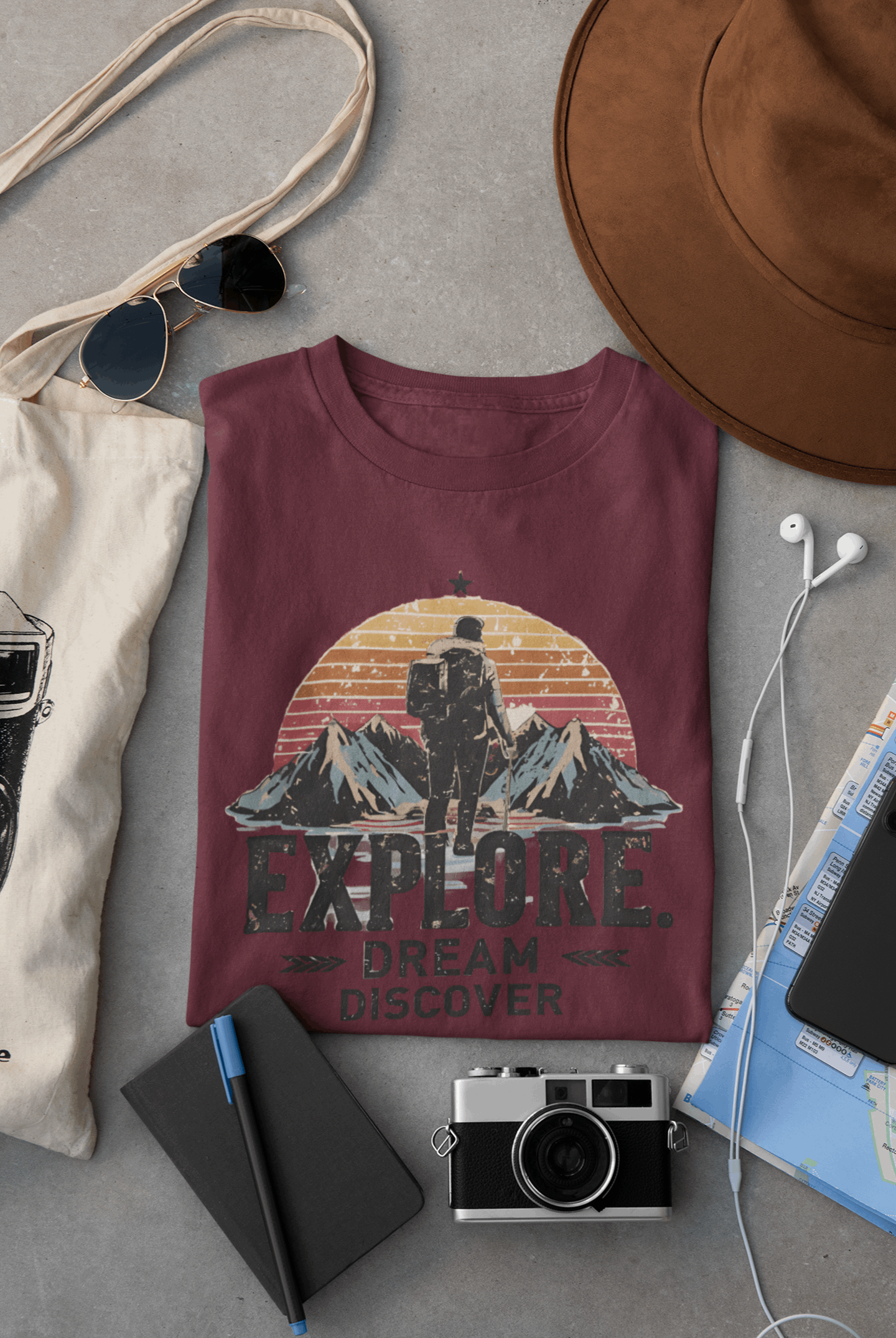 Wyld Peak Explorers men’s organic cotton t-shirt in maroon laid flat on a desk