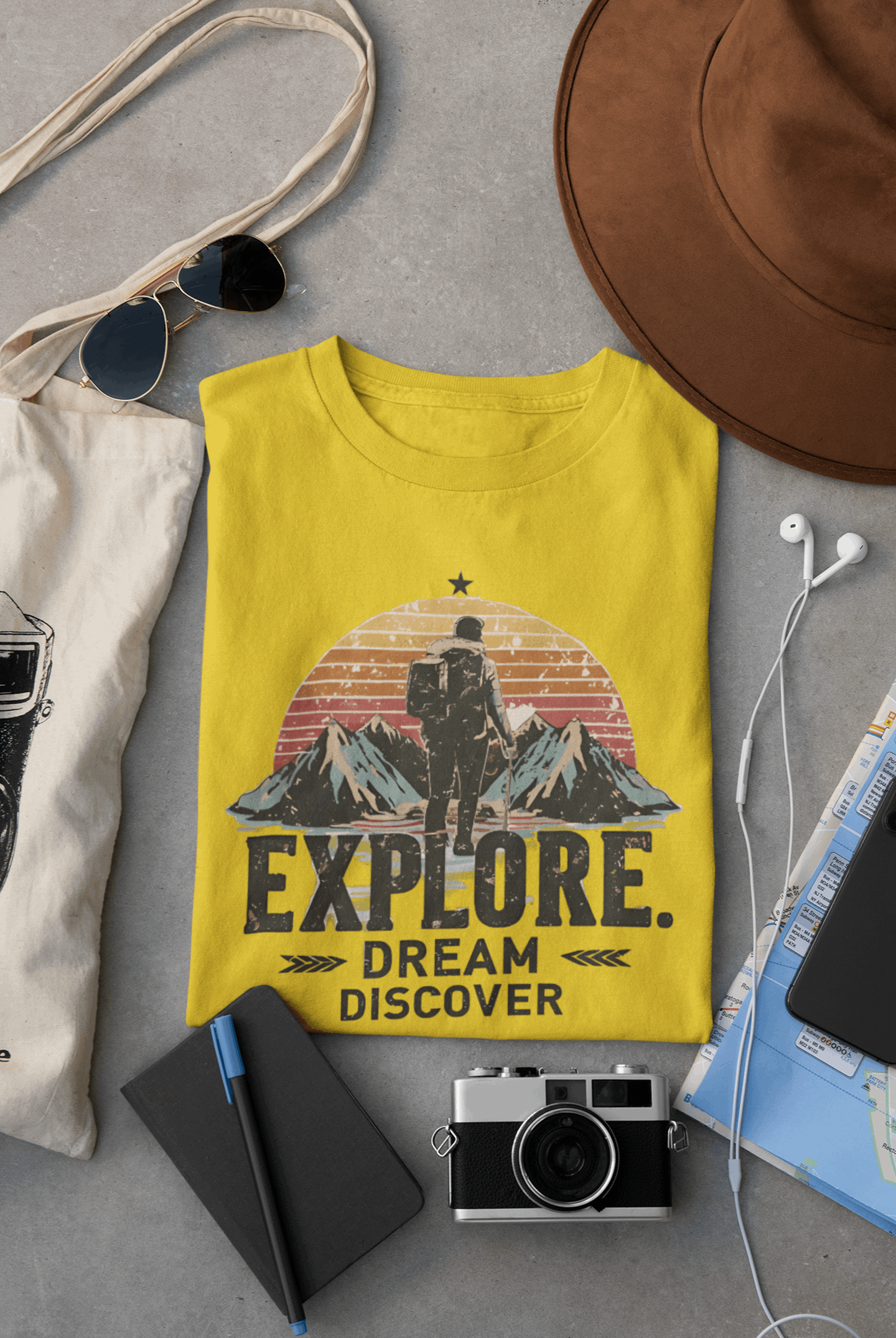 Wyld Peak Explorers men’s organic cotton t-shirt in yellow laid flat on a desk
