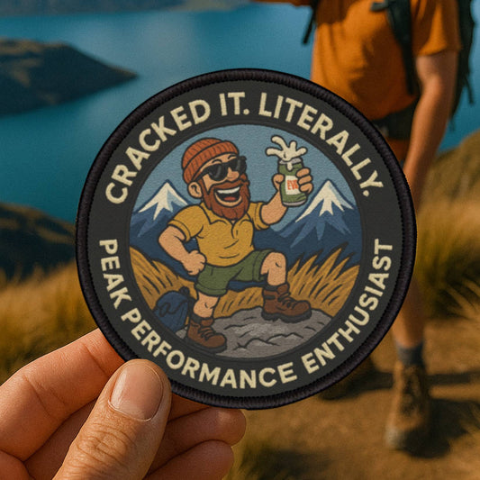 Summit Sip Club patch on a trail summit as a hiker cracks open a beer