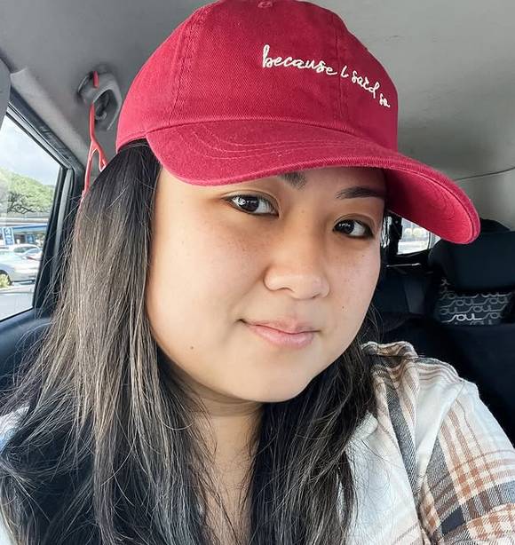 Owlsaur (Ali) takes a selfie in her car in Honolulu, wearing a Wyld Peak baseball cap
