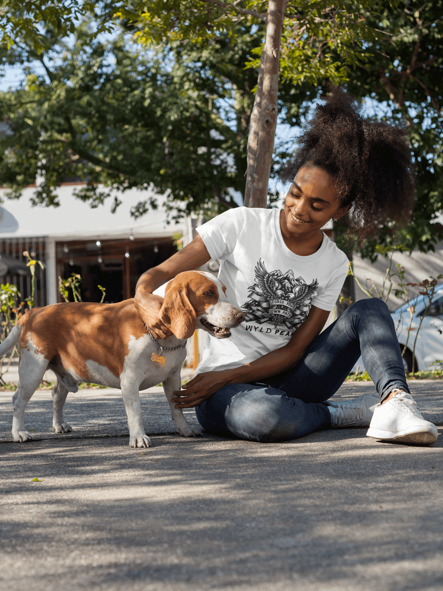 Lifestyle shot of Wyld Peak American Design tee in white on a woman at a basketball court.