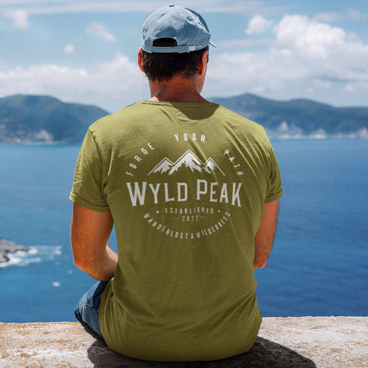 Backshot of man wearing Wyld Peak classic tee in military green overlooking cliff.