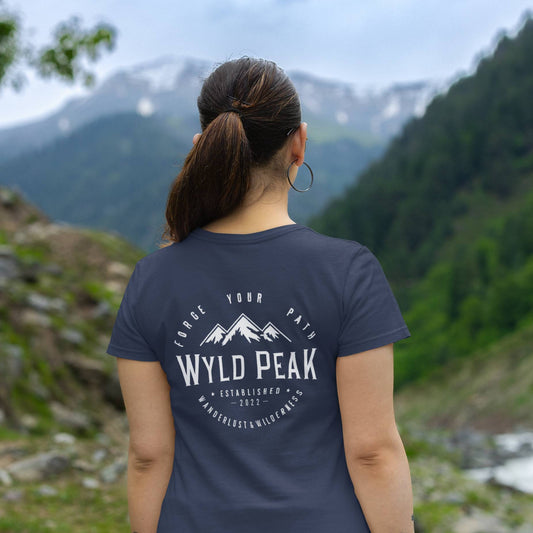 Backshot of woman hiking in Wyld Peak classic tee in navy.