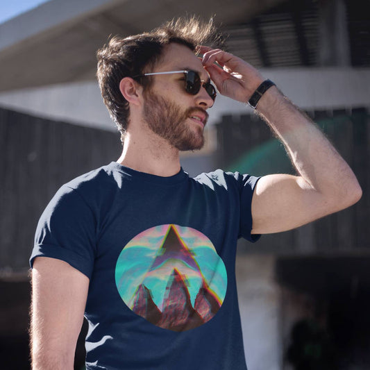 A man wearing sunglasses and a navy blue organic cotton hiking t-shirt with a geometric mountain design in the center.