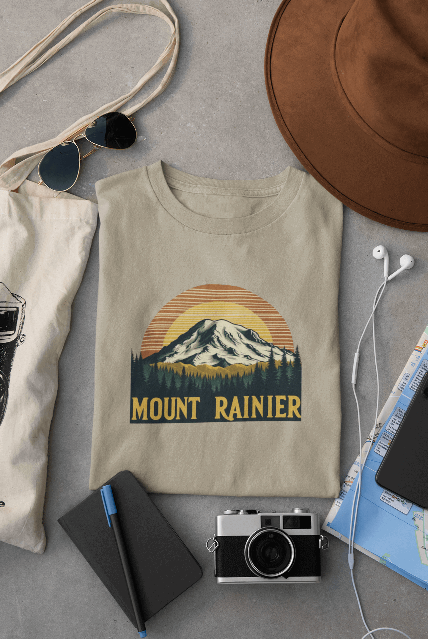 Wyld Peak Mount Rainier National Park organic cotton tee in desert tan laid flat on desk.