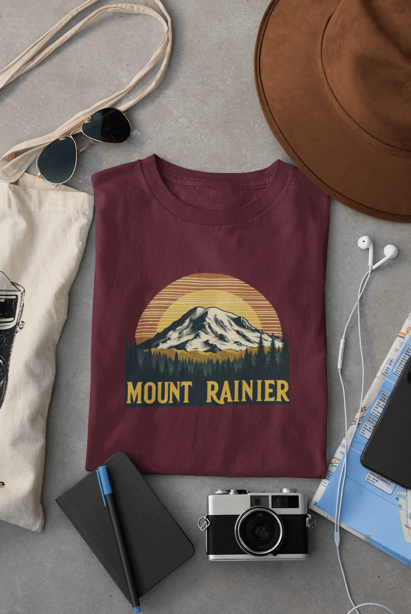Maroon Wyld Peak Mount Rainier National Park organic cotton tee laid flat on desk.