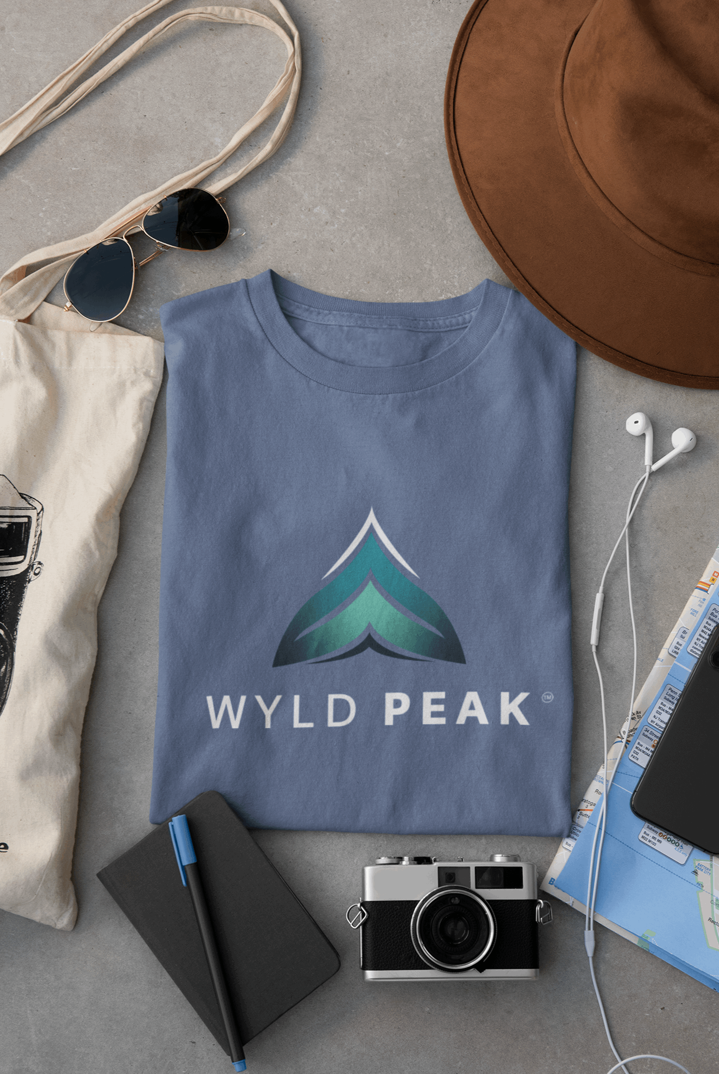 Indigo blue Wyld Peak women’s branded tee laid flat on desk.