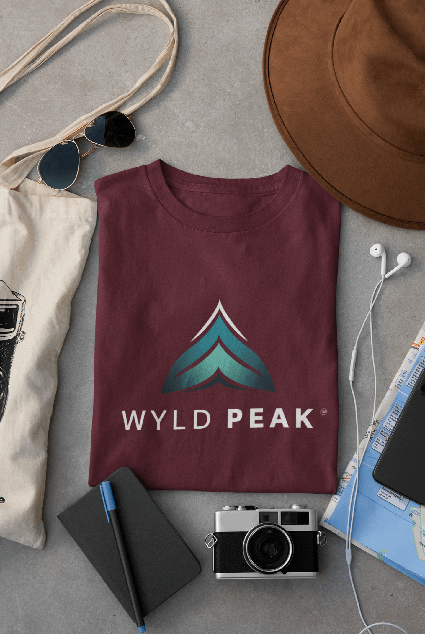 Maroon Wyld Peak women’s branded tee laid flat on desk.