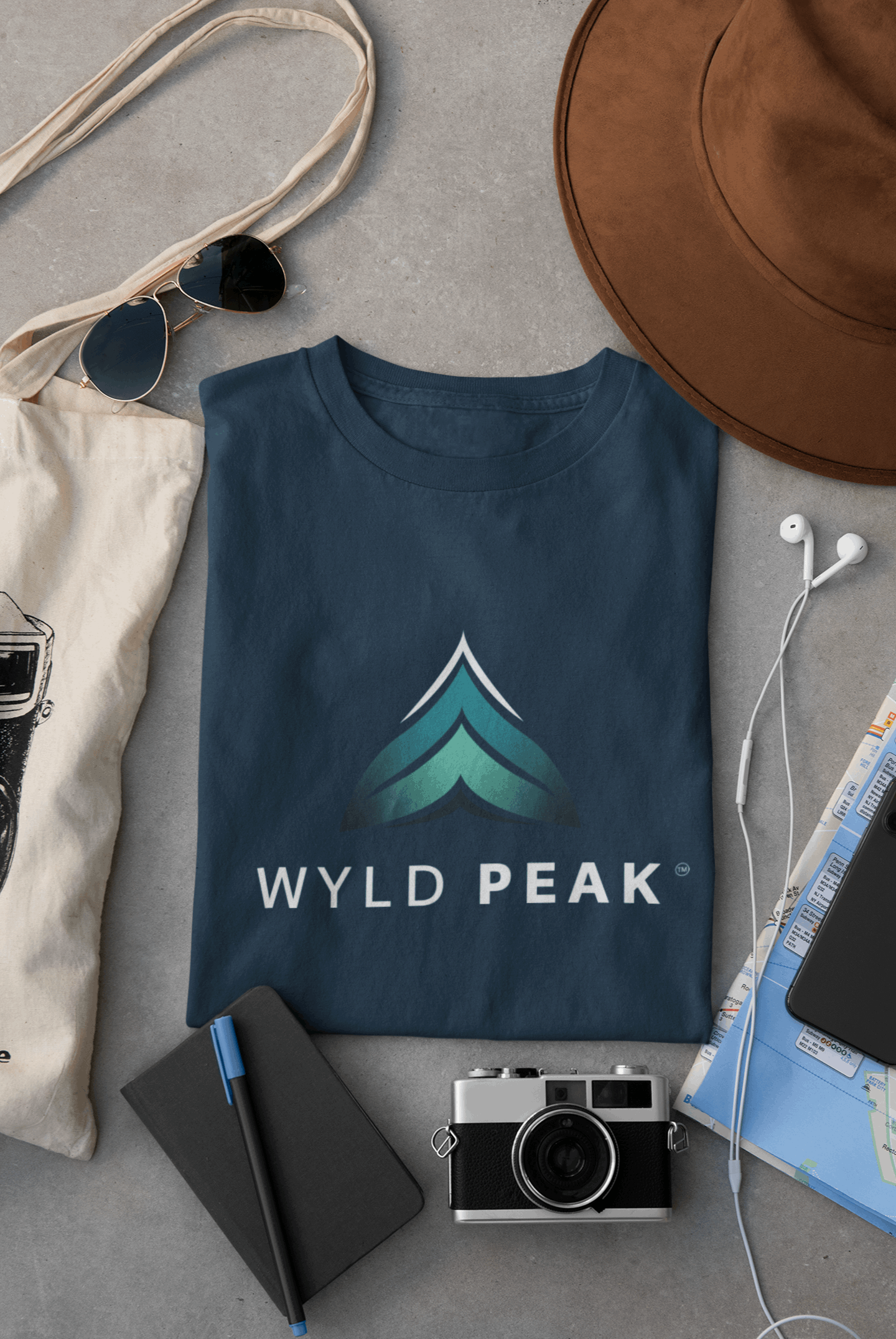 Navy Wyld Peak women’s branded tee laid flat on desk.